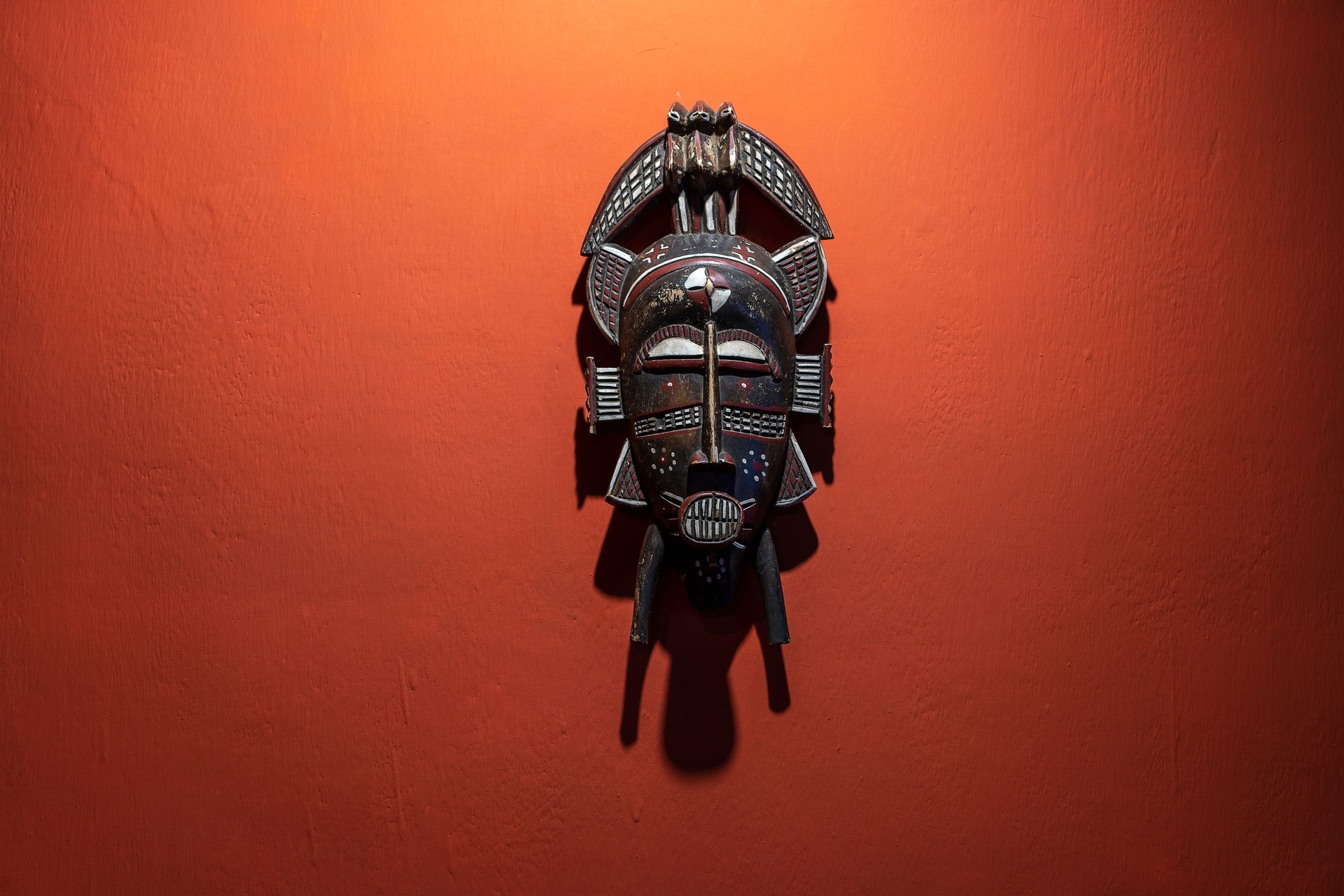 Wooden african mask on a stone wall background, Tanzania, Africa. Close up